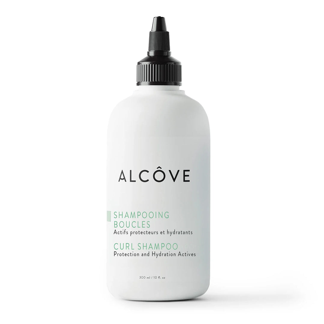 Flacon de 300 ml du shampooing boucles Alcôve avec embout applicateur, présenté sur fond blanc. Soin sans sulfates pour cheveux bouclés.