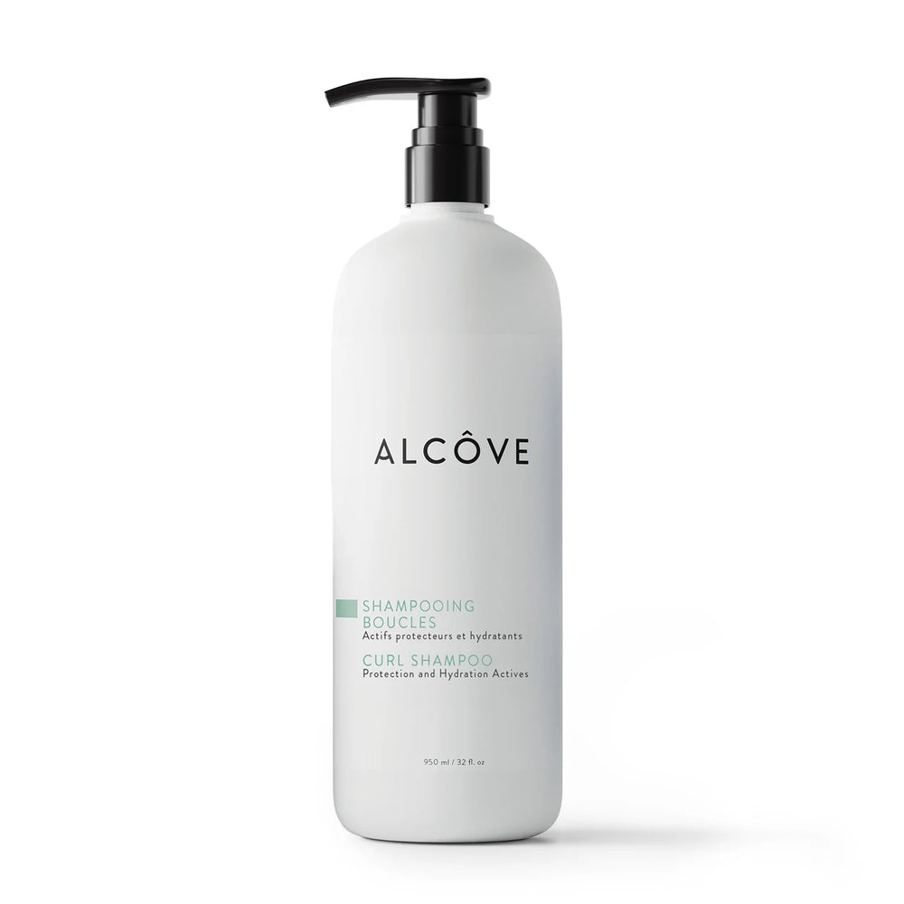Flacon pompe de 950 ml du shampooing boucles Alcôve, soin hydratant et protecteur pour cheveux bouclés, présenté sur fond blanc.