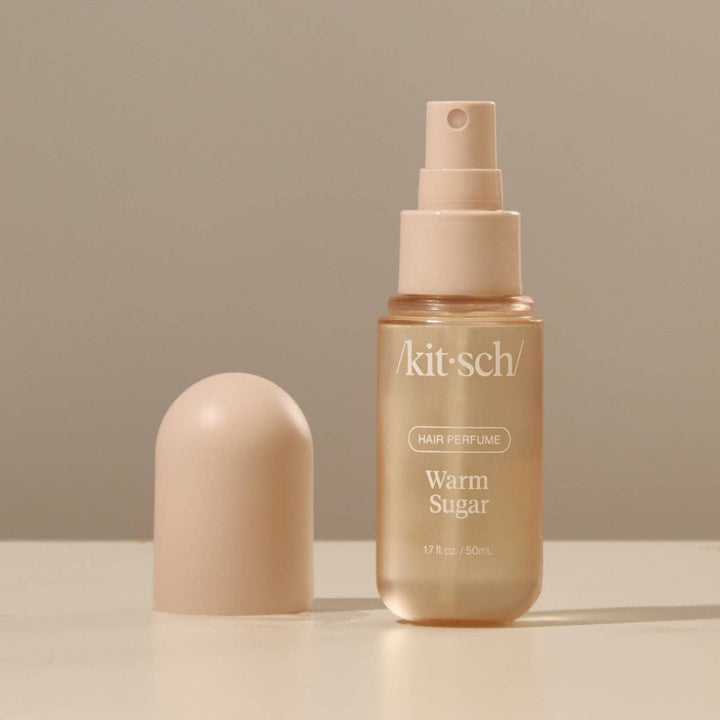 Flacon ouvert du parfum pour cheveux KITSCH Warm Sugar 50 ml montrant le vaporisateur sur fond beige minimaliste.