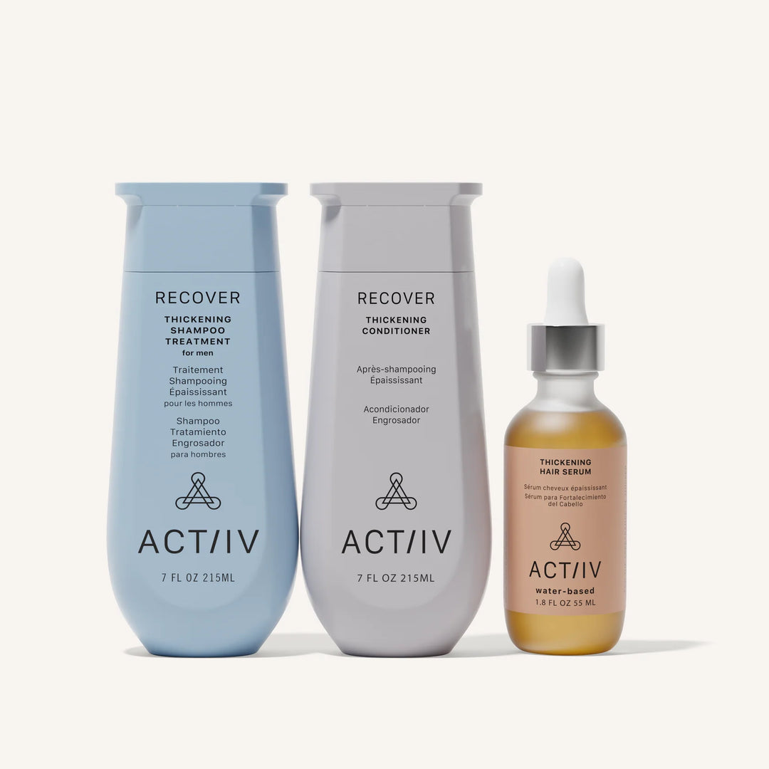 Ensemble produits capillaires ACT/IV RECOVER comprenant shampooing bleu, revitalisant gris et sérum ambré alignés sur fond blanc minimaliste style studio professionnel