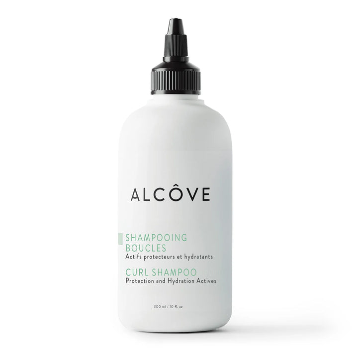 Flacon de 300 ml du shampooing boucles Alcôve avec embout applicateur, présenté sur fond blanc. Soin sans sulfates pour cheveux bouclés.