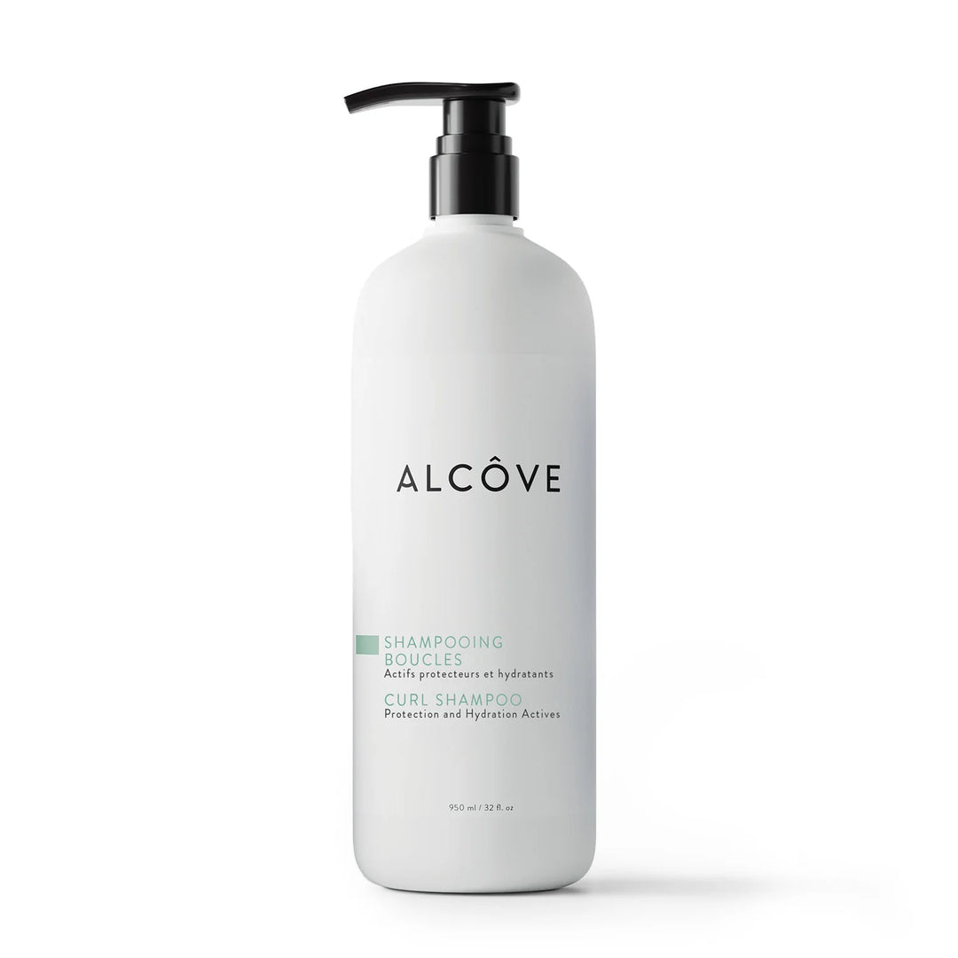 Flacon pompe de 950 ml du shampooing boucles Alcôve, soin hydratant et protecteur pour cheveux bouclés, présenté sur fond blanc.