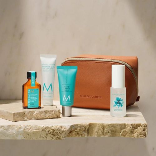 Image du Coffret Corps Moroccanoil comprenant une brume pour le corps 30 ml, un gel douche 25 ml, une huile traitante originale 25 ml et une crème pour les mains 40 ml dans une pochette raffinée.