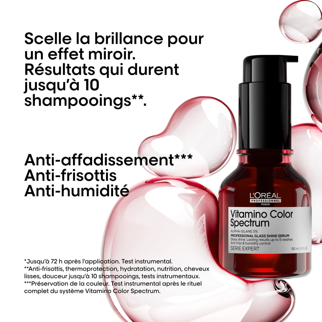 Sérum brillance Vitamino Color Spectrum de L’Oréal Professionnel dans une bouteille pompe rouge foncé 50 ml, sur fond graphique de bulles rosées. Texte en noir : effet miroir jusqu’à 10 shampoings, anti-affadissement, anti-frisottis et anti-humidité.