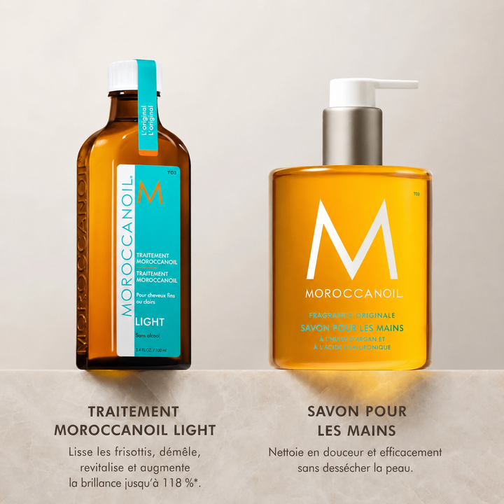 Traitement Moroccanoil Light pour cheveux fins et savon pour les mains Moroccanoil Fragrance Originale en bouteilles ambrées sur comptoir beige.