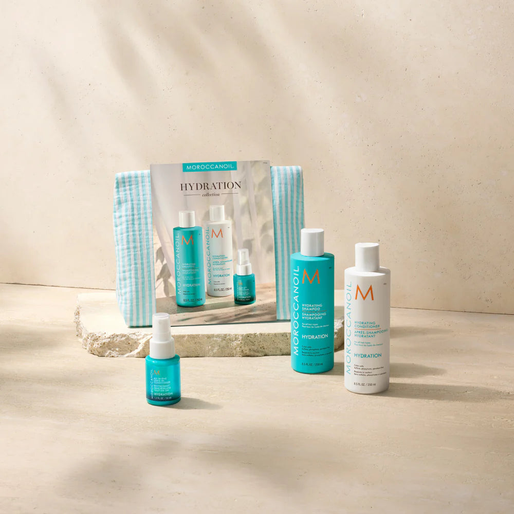 Coffret Hydration Moroccanoil avec shampoing hydratant, revitalisant hydratant, soin sans rinçage et trousse turquoise sur fond beige.