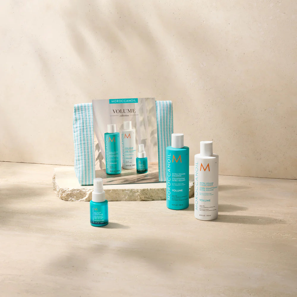 Coffret Volume Moroccanoil avec shampoing Extra Volume, revitalisant Extra Volume, soin sans rinçage et trousse turquoise sur fond beige lumineux.