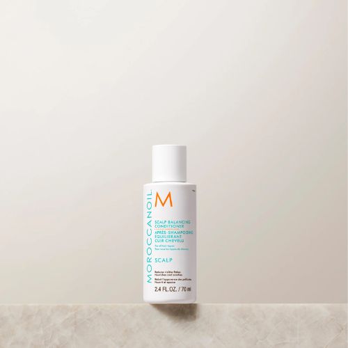Revitalisant Moroccanoil Équilibrant pour le cuir chevelu, format 70 ml. Bouteille blanche au design épuré, logo orange et inscriptions turquoise. Soin après-shampoing équilibrant pour cuir chevelu sensible, posé sur une surface en marbre beige avec fond neutre et minimaliste.