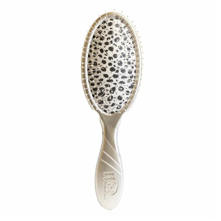 Brosse à démêler Wet Brush Pro Cheetah vue de face sur fond blanc, manche champagne et coussin imprimé animalier noir et blanc.