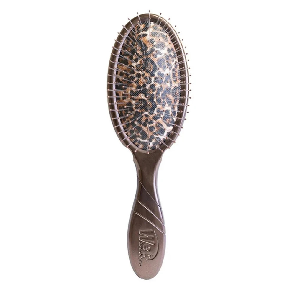 Wet Brush Pro brosse démêlante Léopard avec manche bronze, picots flexibles et coussin à motif léopard brun, beige et noir, sur visuel animalier.