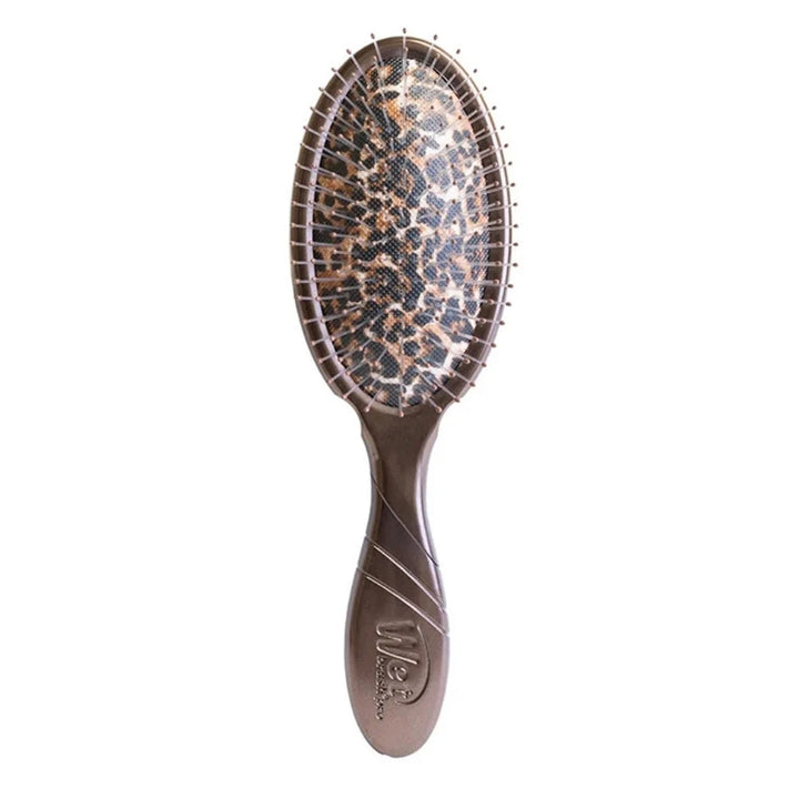 Wet Brush Pro brosse démêlante Léopard avec manche bronze, picots flexibles et coussin à motif léopard brun, beige et noir, sur visuel animalier.