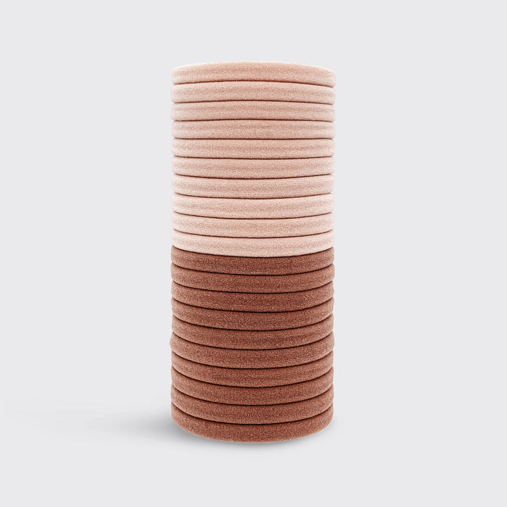 Élastiques KITSCH rose poudré et vieux rose en nylon recyclé disposés sur fond gris clair, accessoires cheveux doux sans couture pour tous types de cheveux.
