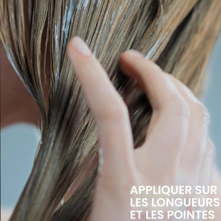 Application de l’après-shampoing Redken Acidic Grow Full sur cheveux mouillés, soin réparti sur les longueurs et pointes pour hydrater et renforcer les cheveux fins.