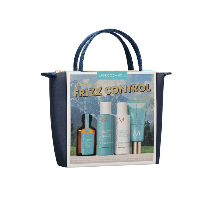Coffret Moroccanoil Frizz Control dans une pochette bleu marin avec shampoing anti-frisottis, revitalisant, huile Moroccanoil et crème pour les mains illustrés sur l’emballage, photographié sur fond blanc. 