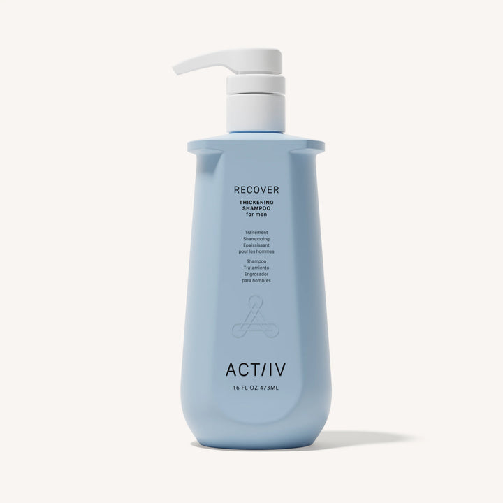 Flacon bleu shampoing épaississant ACT/IV Recover pour homme avec pompe blanche, format 473 ml, design minimaliste sur fond neutre.
