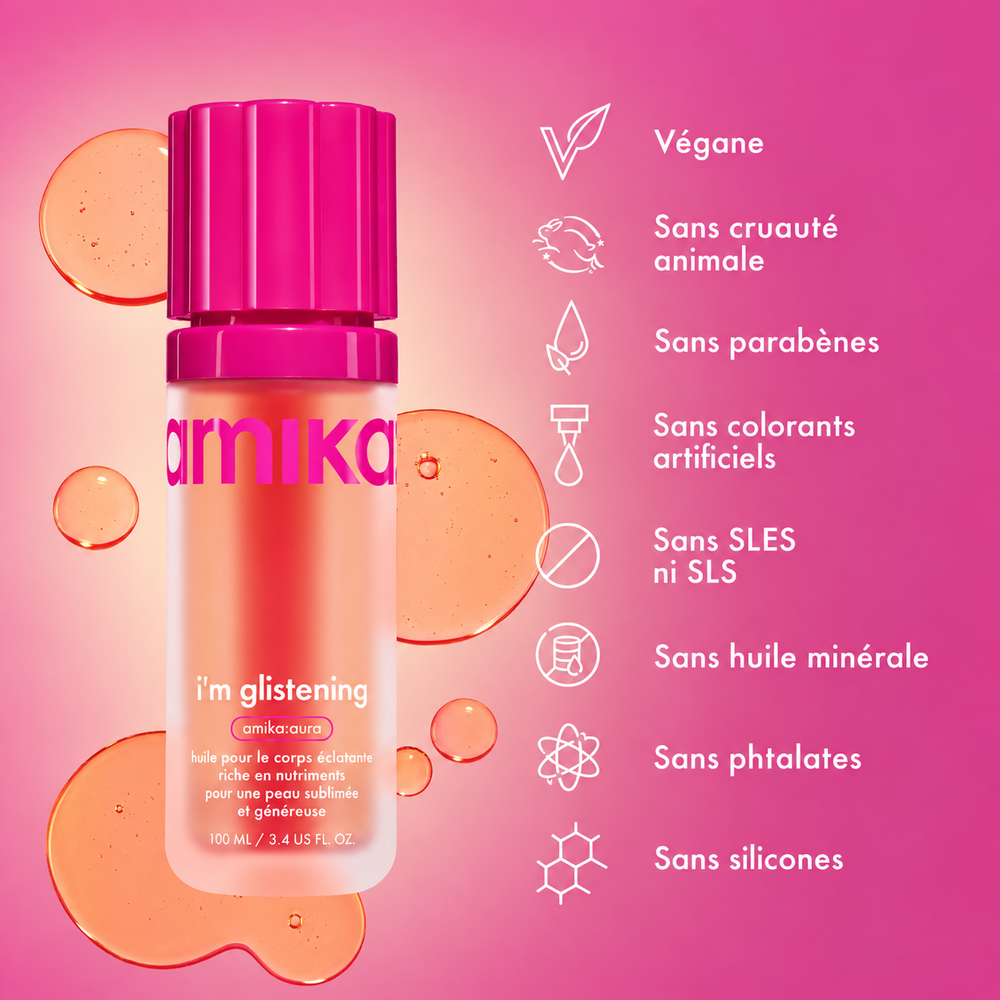 huile corporelle éclatante en flacon rose entouré de gouttes d'huile sur fond rose, format de 100 ml.