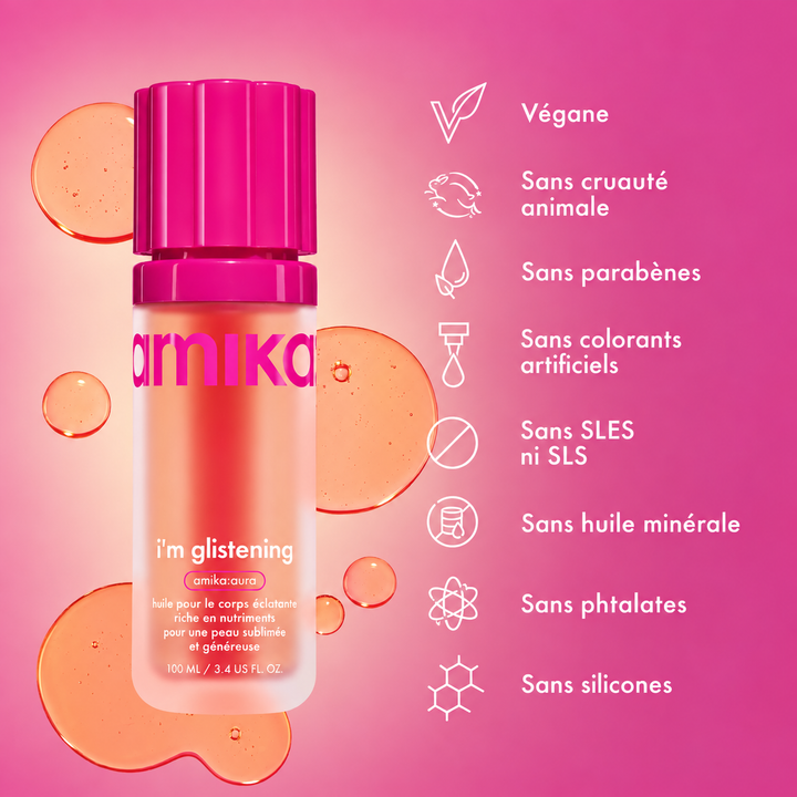 huile corporelle éclatante en flacon rose entouré de gouttes d'huile sur fond rose, format de 100 ml.