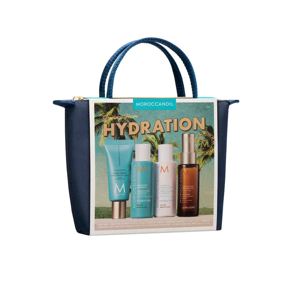 Coffret Moroccanoil Hydration placé dans une pochette bleu marin avec illustration des produits hydratants comprenant crème pour les mains, shampoing, revitalisant et traitement Moroccanoil, photographié sur fond blanc.