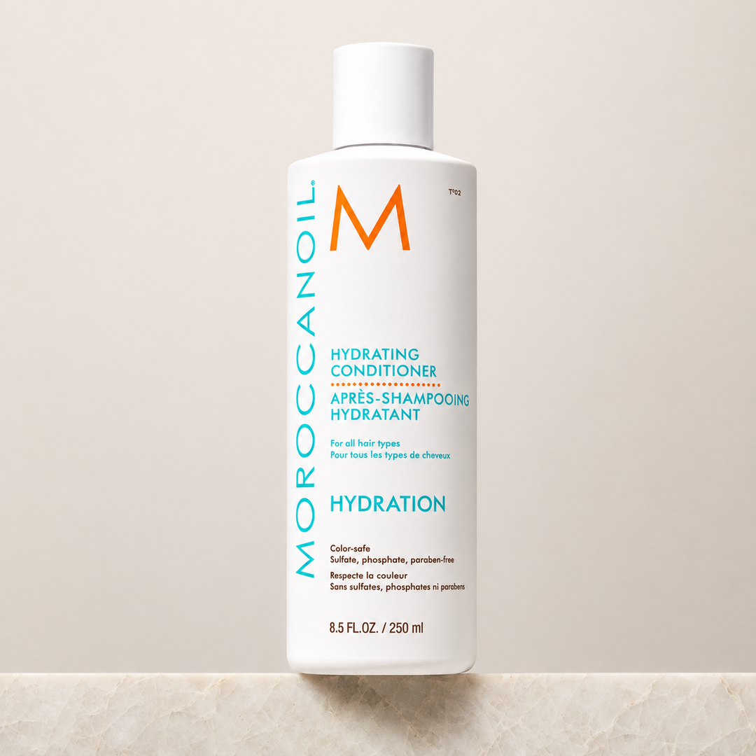 Après-shampoing hydratant Moroccanoil Hydration 250 ml en bouteille blanche avec bouchon blanc, posé sur un fond beige minimaliste, photo produit professionnelle.