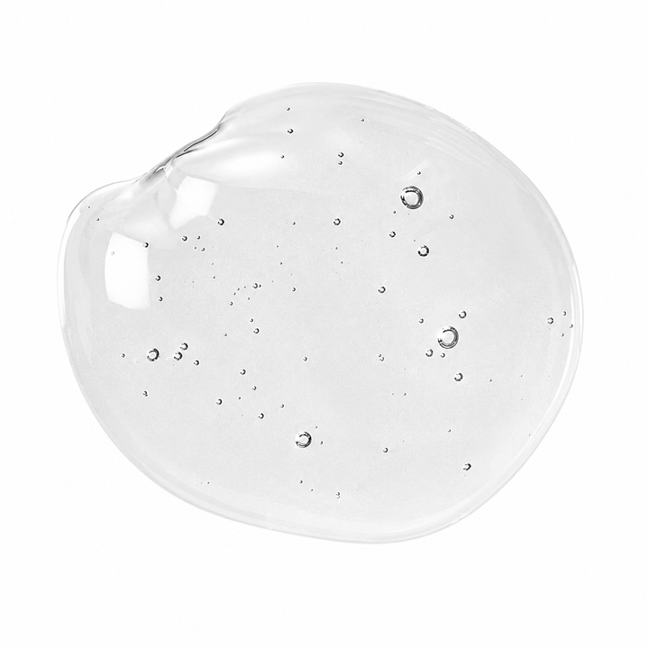 Texture de sérum transparent à l’acide hyaluronique présentée en goutte épaisse sur fond blanc, avec fines bulles d’air visibles.