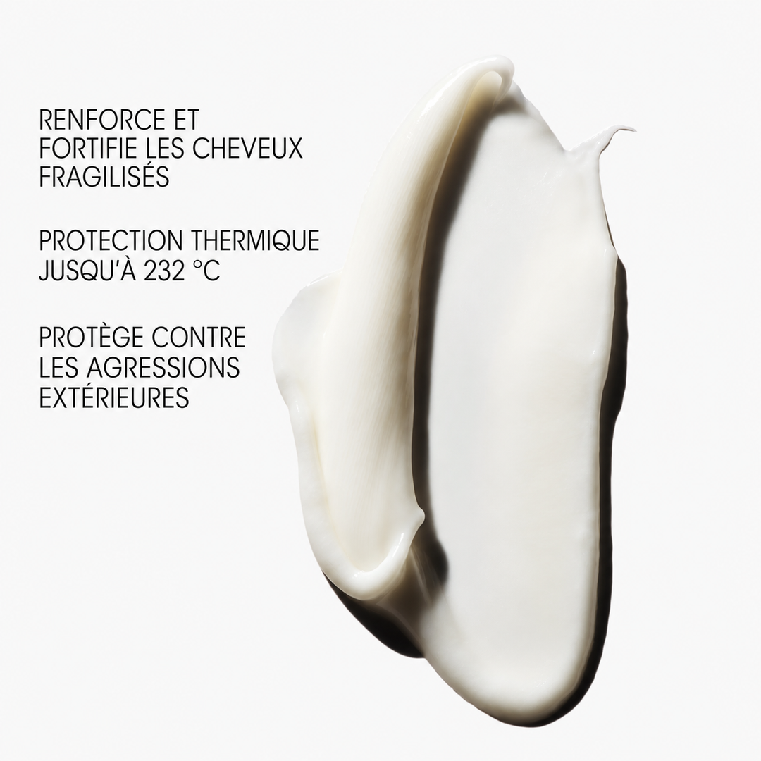 « Texture crémeuse blanche du soin fortifiant ORIBE Hair Alchemy sur fond clair, avec mentions de protection thermique jusqu’à 232 °C et de renforcement des cheveux fragiles. »