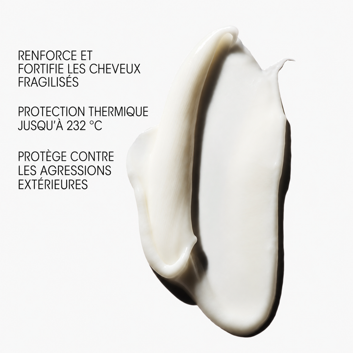 « Texture crémeuse blanche du soin fortifiant ORIBE Hair Alchemy sur fond clair, avec mentions de protection thermique jusqu’à 232 °C et de renforcement des cheveux fragiles. »