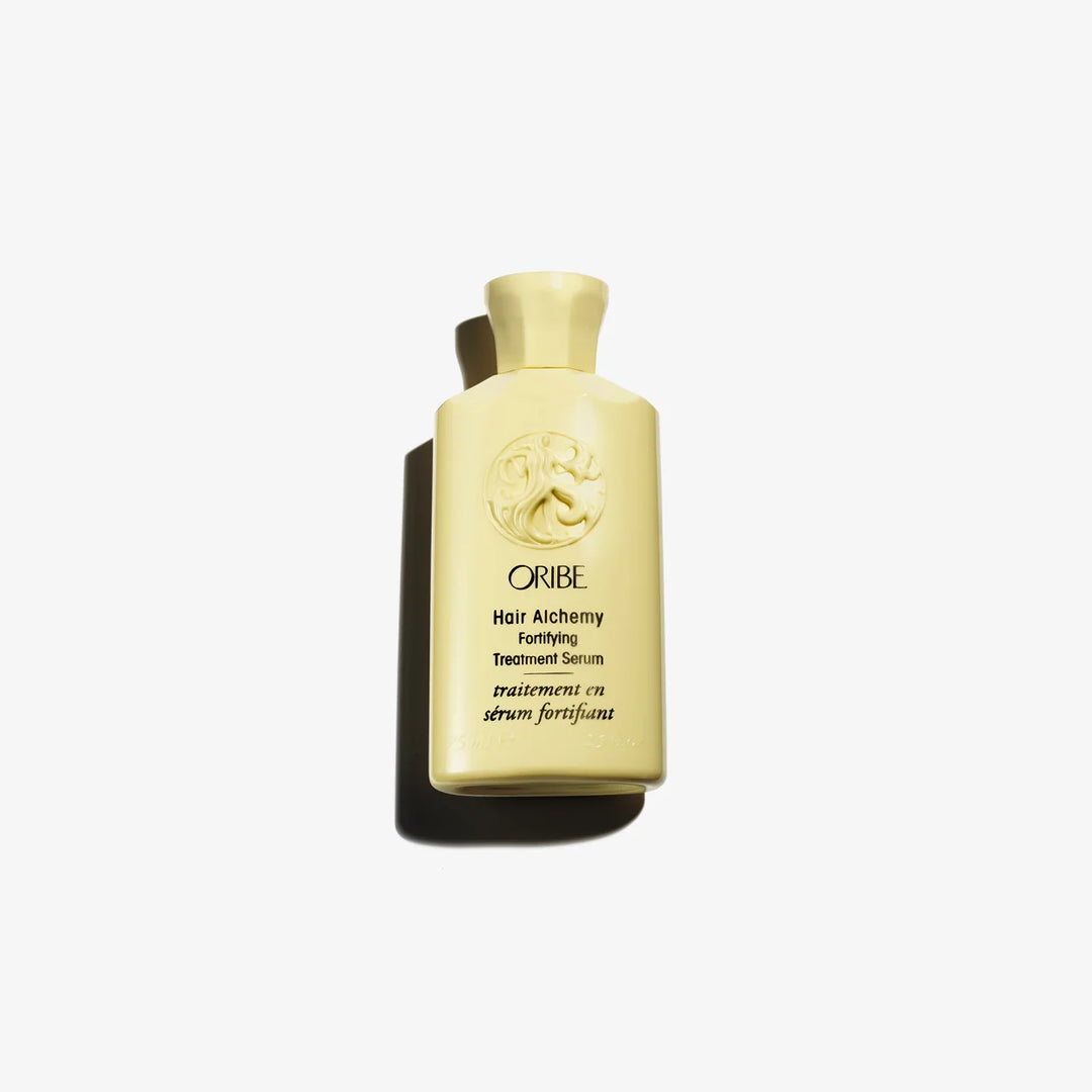 « Sérum fortifiant ORIBE Hair Alchemy dans un flacon jaune pâle avec bouchon assorti, logo embossé et lettrage noir, sur fond blanc. »
